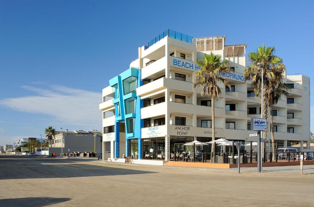 un grande edificio con palme di fronte di Beach Hotel Swakopmund a Swakopmund