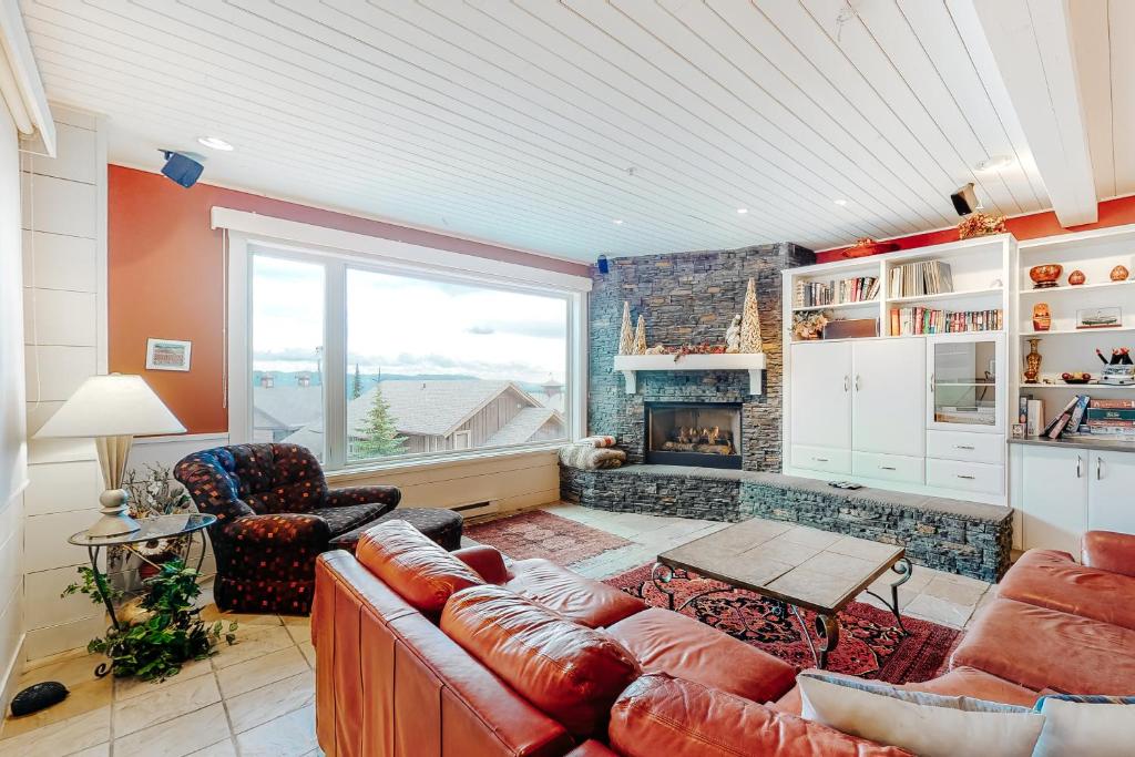 Una sala de estar con un sofá y una chimenea. en Yankee Sno-Home, en Big White