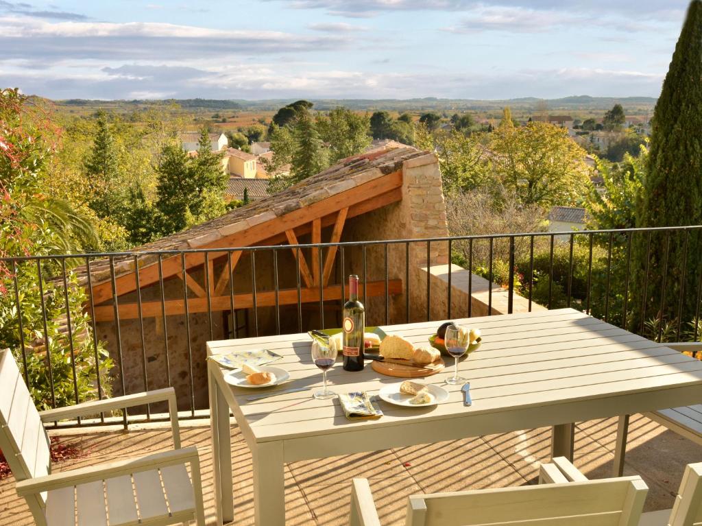 een witte tafel en stoelen op een balkon bij L'Olivier in Néffiès