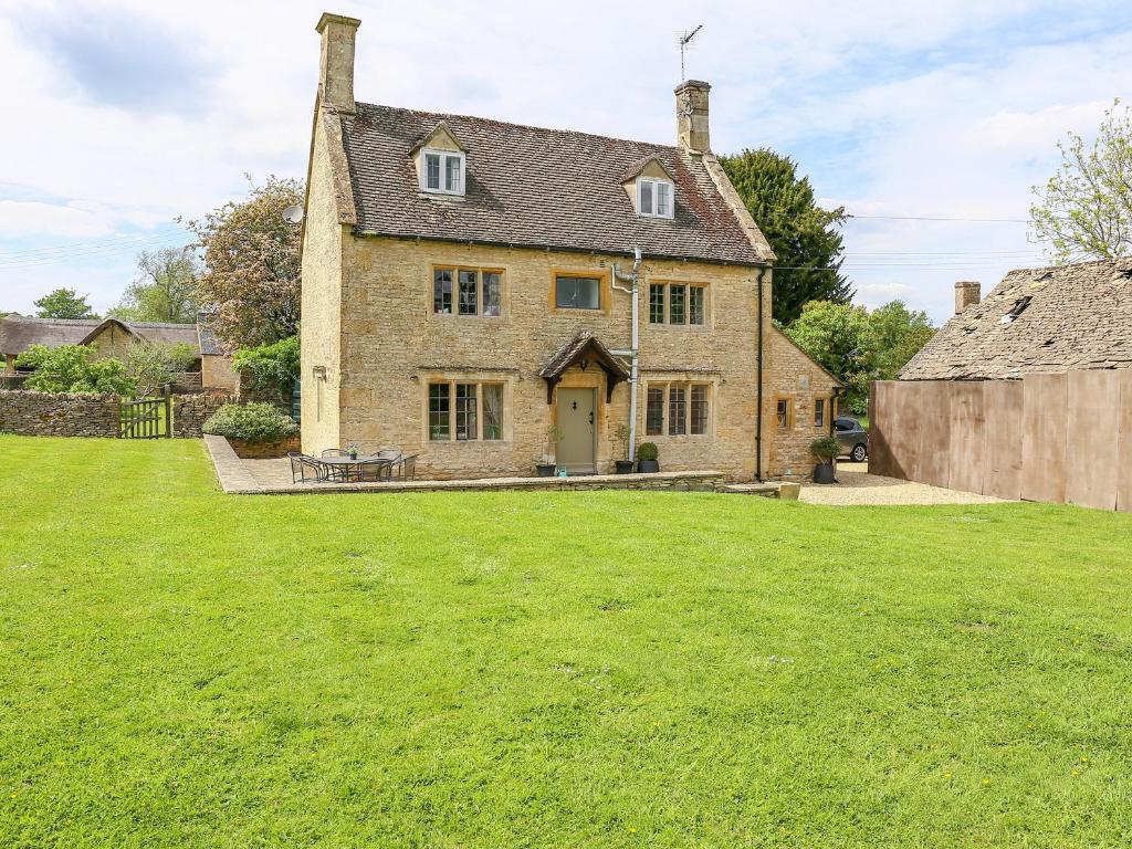 an old brick house with a grass yard at The Smithy in Stow on the Wold