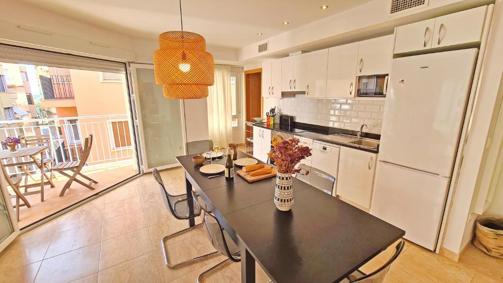 een keuken met een tafel met daarop een vaas met bloemen bij Luxury City Center Apartment by NRAS in Alicante