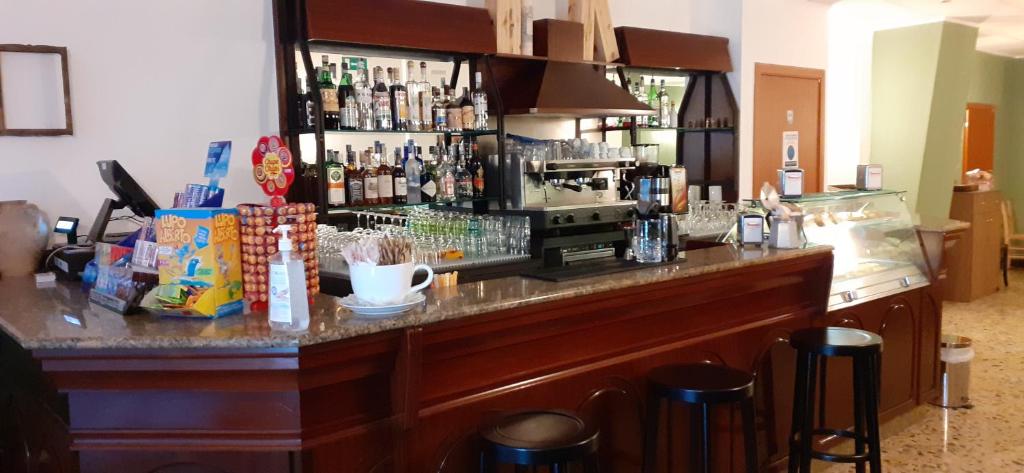 a bar in a restaurant with a counter and stools at Hotel Ristorante Cibarium in Gualdo Tadino