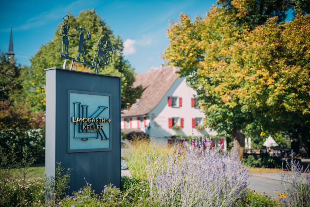 a sign in a garden with a house in the background at Landgasthof Keller in Überlingen