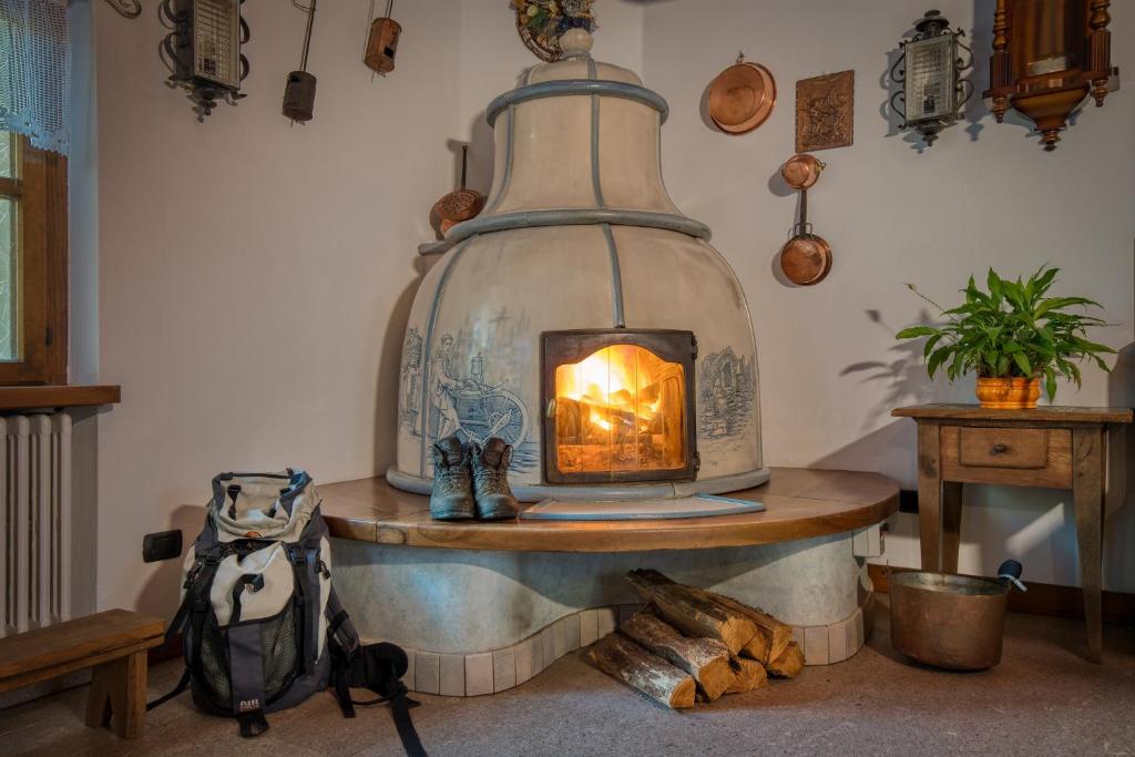a wood burning stove in a room with a backpack at Albergo Moleta in Spiazzo