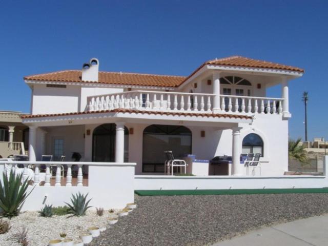 a white house with a balcony and a swimming pool at Casa Las Vistas del Mar by FMI Rentals in Puerto Peñasco