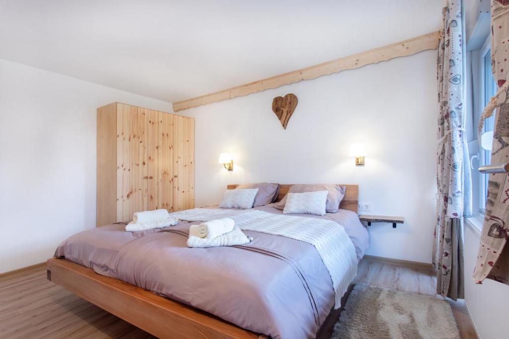 a bedroom with a large bed with towels on it at Honey apartments in Žirovnica