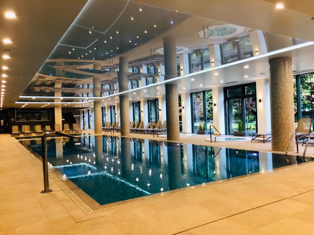 a large swimming pool in a building with a lobby at Apartament S&S Nadmorskie Tarasy Kołobrzeg D302 in Kołobrzeg