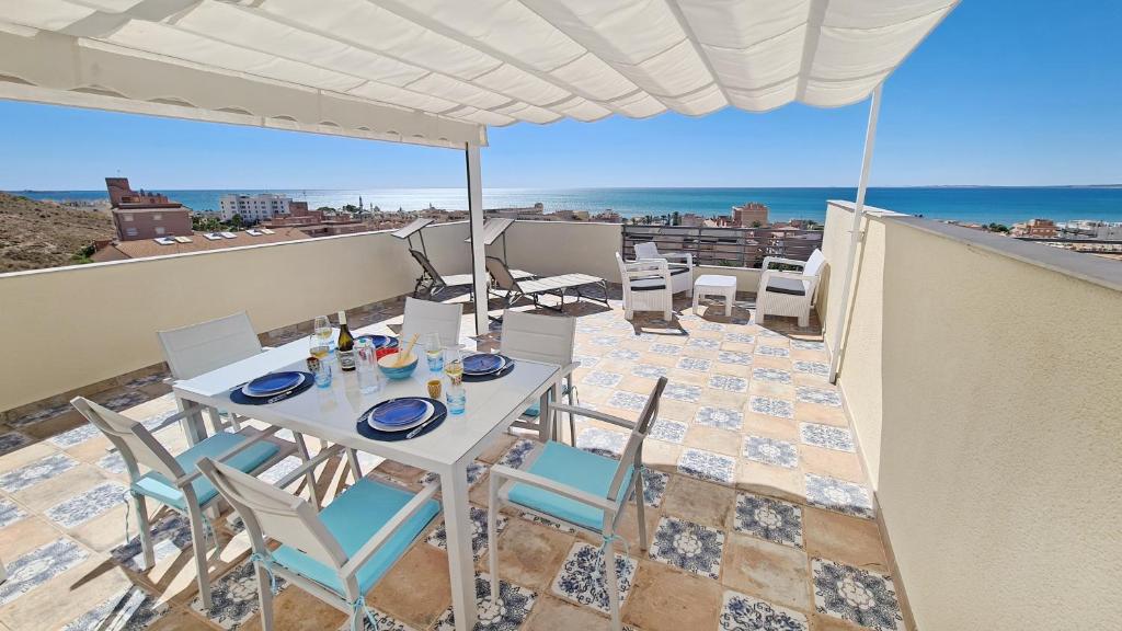 a table and chairs on a balcony with a view of the ocean at Penthouse with Panoramic View by NRAS in Santa Pola