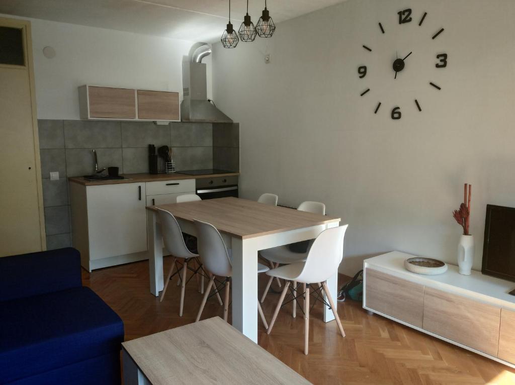 una cocina con mesa y sillas y un reloj en la pared en Apartamento en la Molina en La Molina Alp