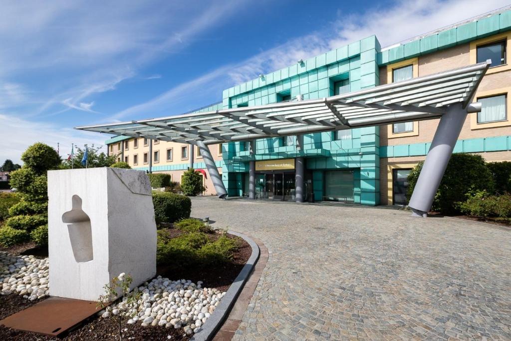 a building with awning in front of it at Crowne Plaza Milan Malpensa Airport, an IHG Hotel in Case Nuove