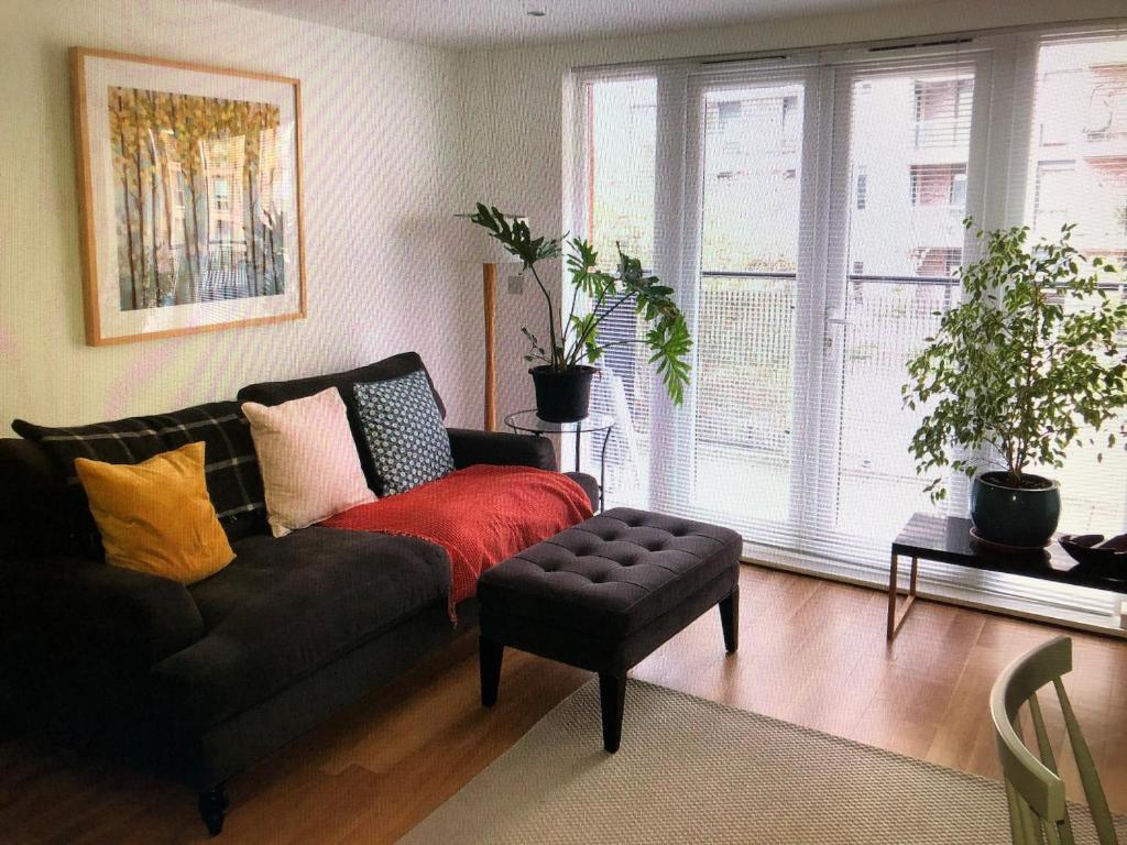 ein Wohnzimmer mit einem Sofa und einem Stuhl in der Unterkunft Kingston Flat in Kingston upon Thames