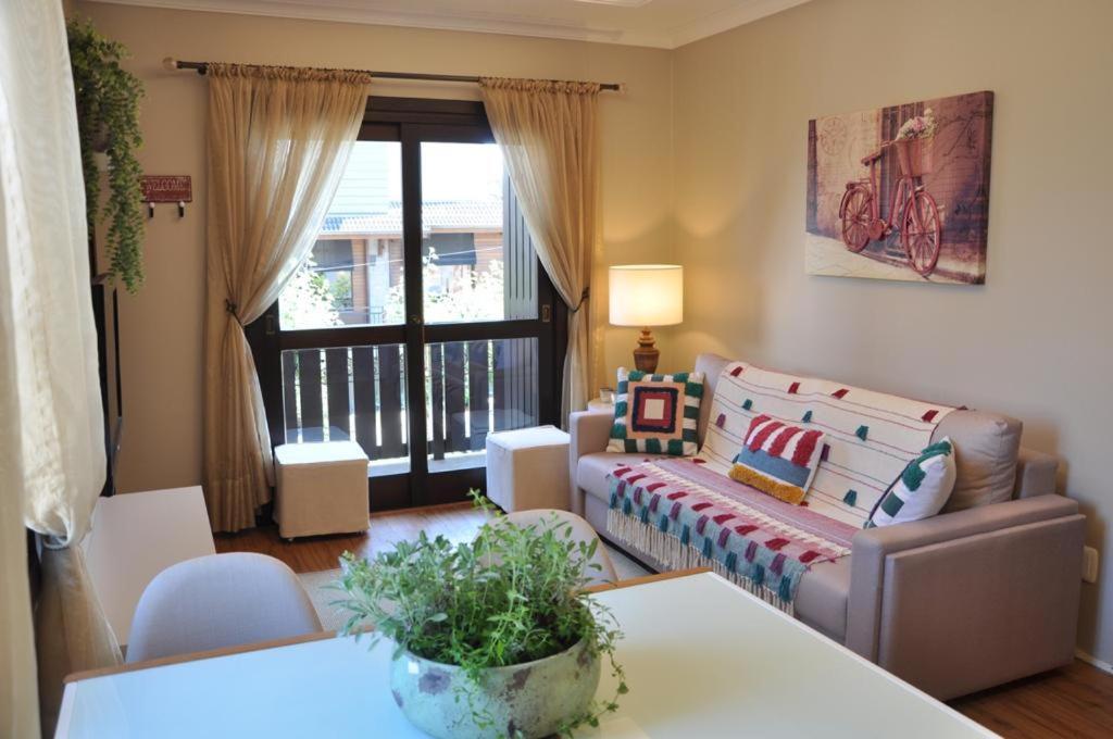 sala de estar con sofá y mesa en Apartamento Florido Centro Gramado, en Gramado