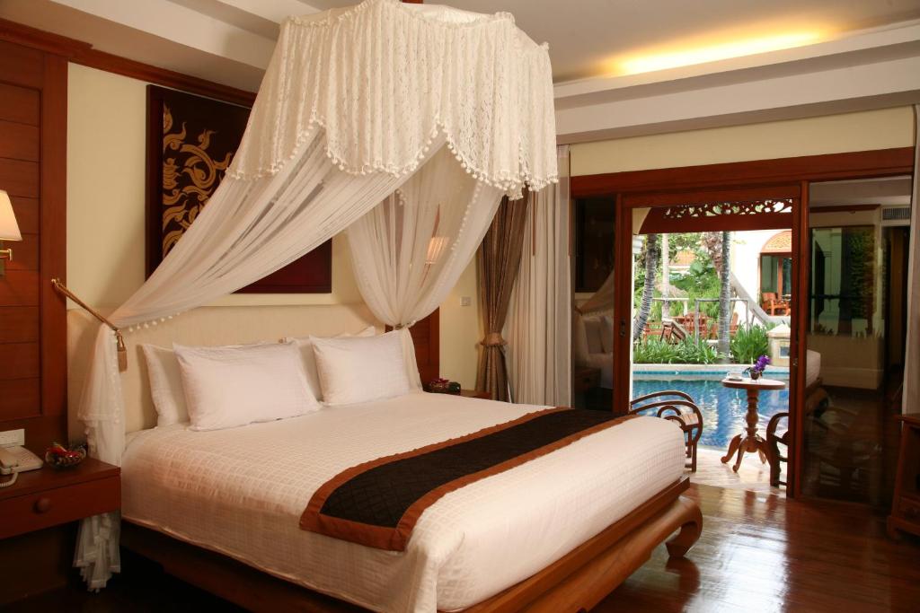 a bedroom with a bed and a chandelier at Khum Phaya Resort & Spa Boutique Collection in Chiang Mai