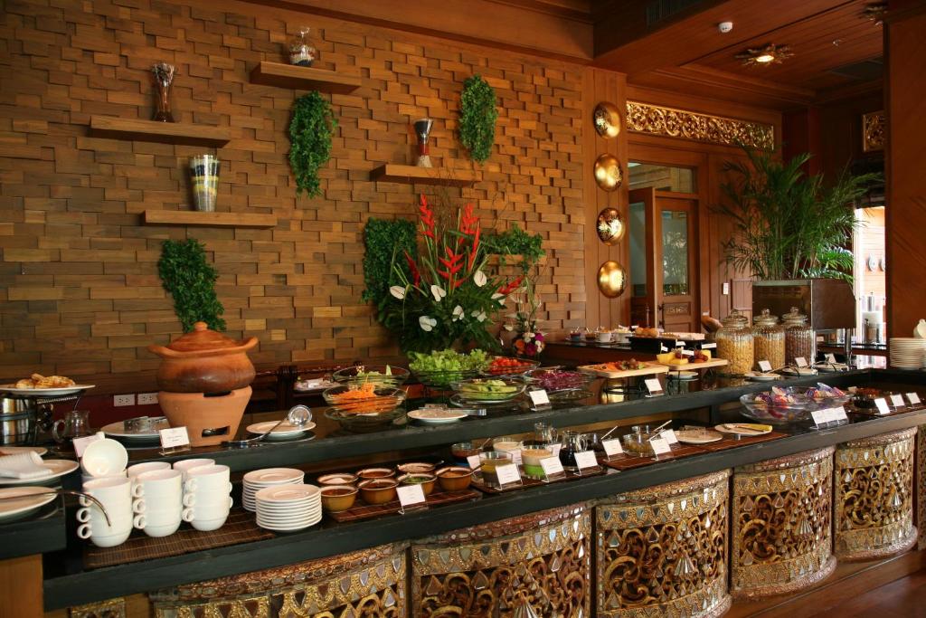 a buffet line in a restaurant with food on it at Khum Phaya Resort & Spa Boutique Collection in Chiang Mai