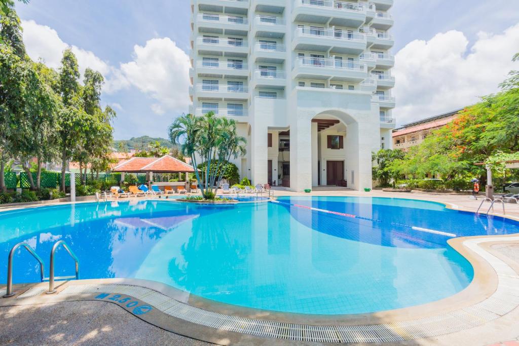 a large swimming pool in front of a building at Waterfront Suites Phuket by Centara in Karon Beach