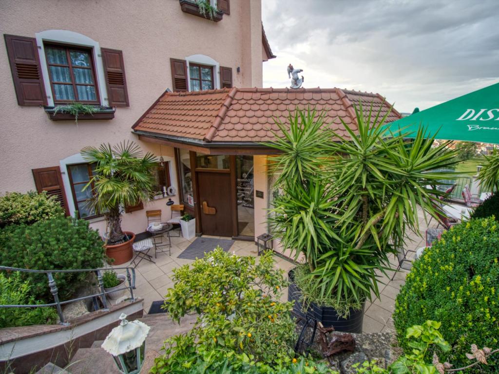 a house with palm trees in front of it at Neckarblick SELF Check IN Hotel in Bad Wimpfen