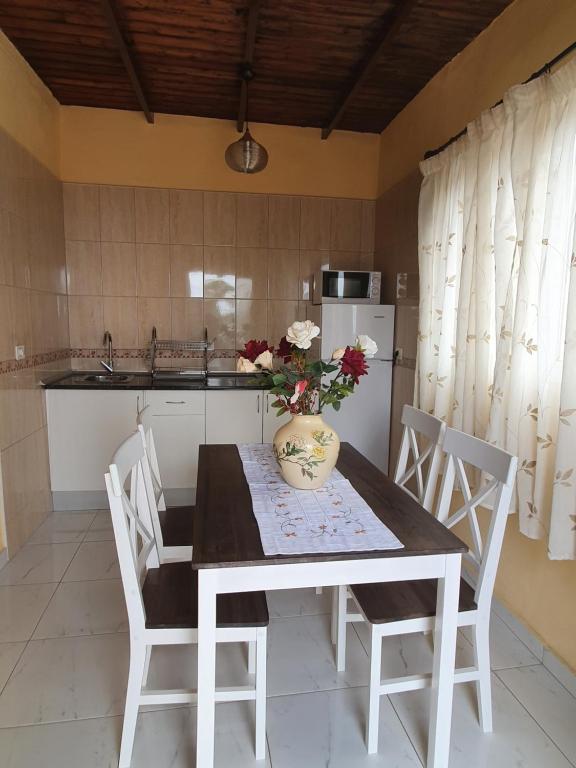 una cocina con una mesa con un jarrón de flores. en Casa Leyla, en Vilaflor
