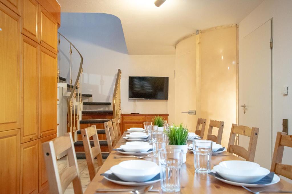 une salle à manger avec une grande table et des plaques blanches dans l'établissement Central City Villa, à Neuss