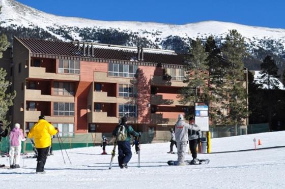 un grupo de personas esquiando en la nieve frente a un edificio en Spruce Lodge en Copper Mountain