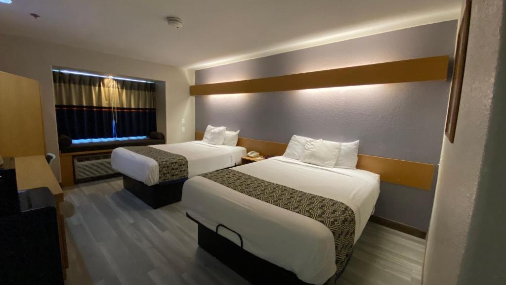 a hotel room with two beds and a window at Microtel Inn & Suites by Wyndham Ardmore in Ardmore