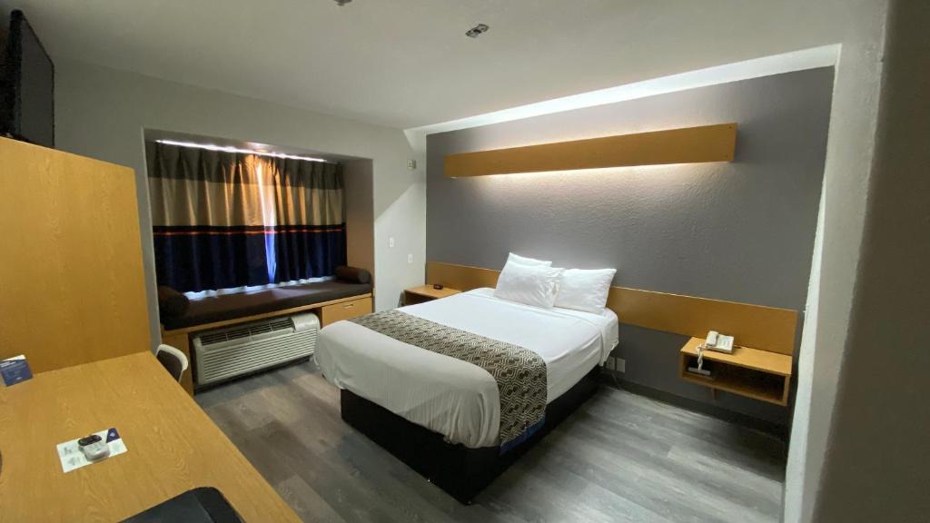 a small room with a bed and a window at Microtel Inn & Suites by Wyndham Ardmore in Ardmore