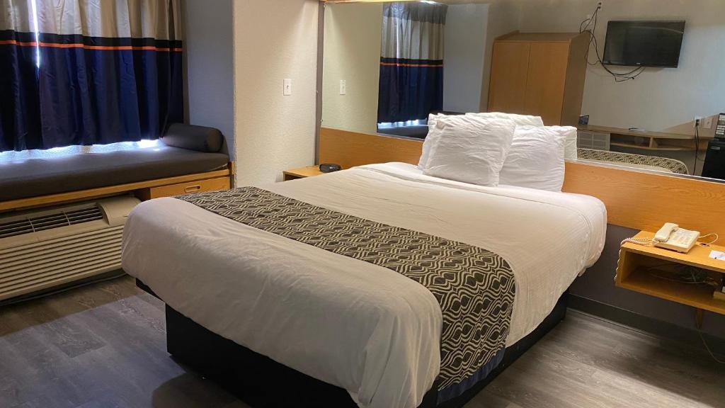 a hotel room with a bed and a couch at Microtel Inn & Suites by Wyndham Ardmore in Ardmore