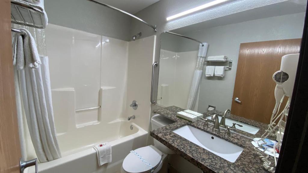 a bathroom with a sink and a shower and a tub at Microtel Inn & Suites by Wyndham Ardmore in Ardmore