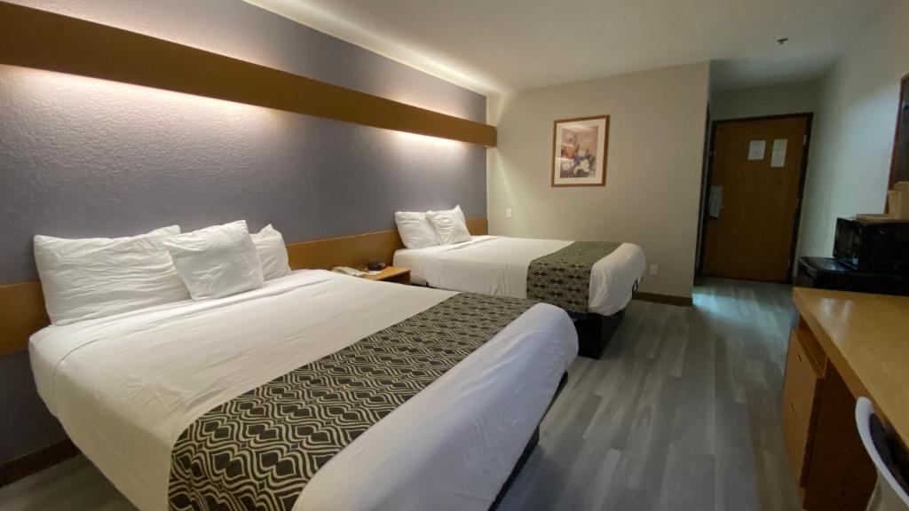 a hotel room with two beds in a room at Microtel Inn & Suites by Wyndham Ardmore in Ardmore
