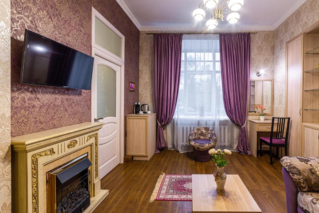 a living room with a fireplace and a tv at Rada mini-hotel in Saint Petersburg