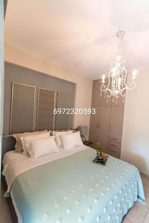 a bedroom with a large bed with a chandelier at Cozy and Style in Preveza