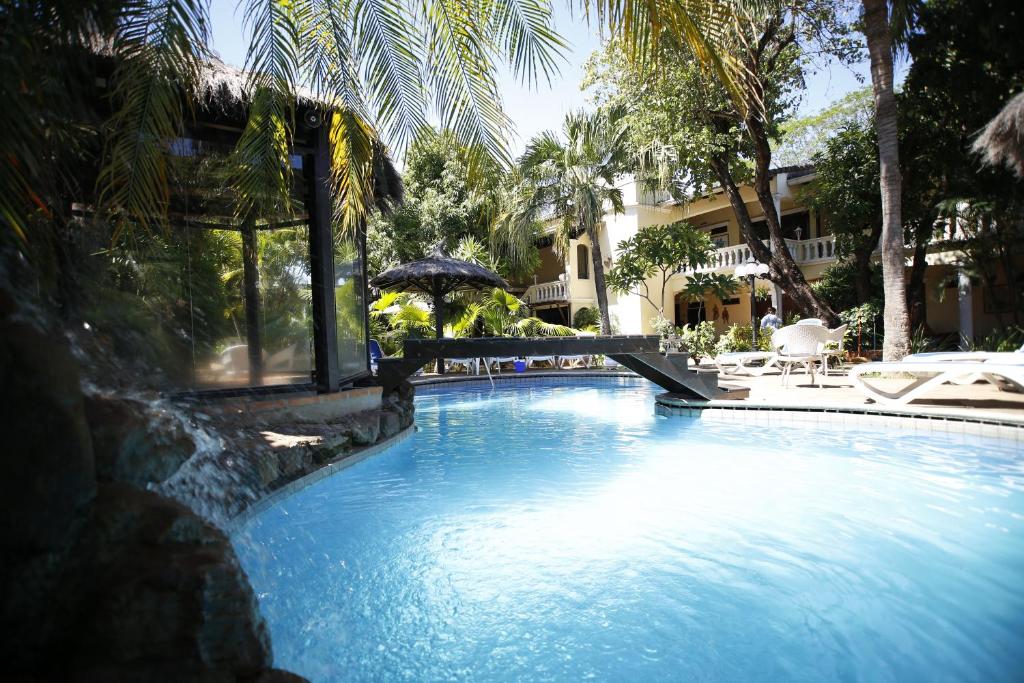uma piscina com guarda-sol e cadeiras e um edifício em Paramanta Lifestyle Hotel em Assunção