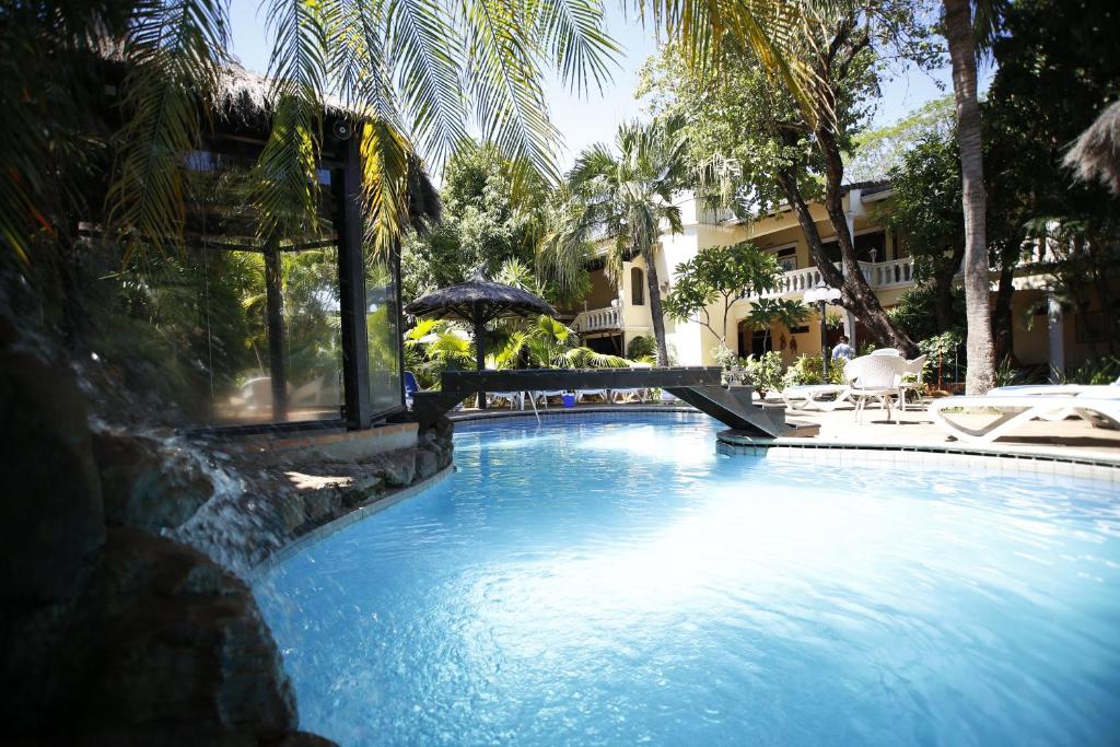 ein Pool mit Sonnenschirm und Stühlen sowie ein Gebäude in der Unterkunft Paramanta Lifestyle Hotel in Asunción