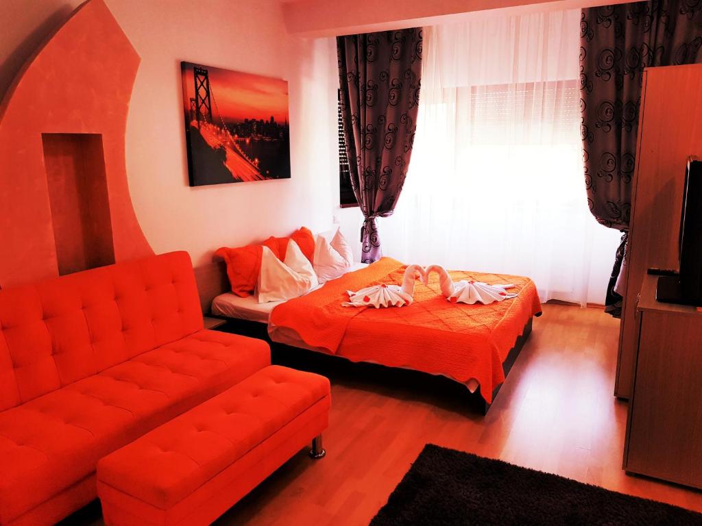 sala de estar con cama y sofá en Pensiunea Red Rose Apartments, en Timisoara
