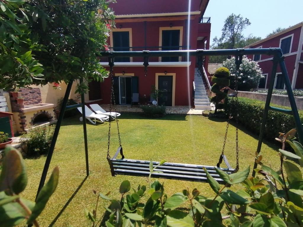 un columpio en un patio con una casa en Conelli Haus, en Liapades