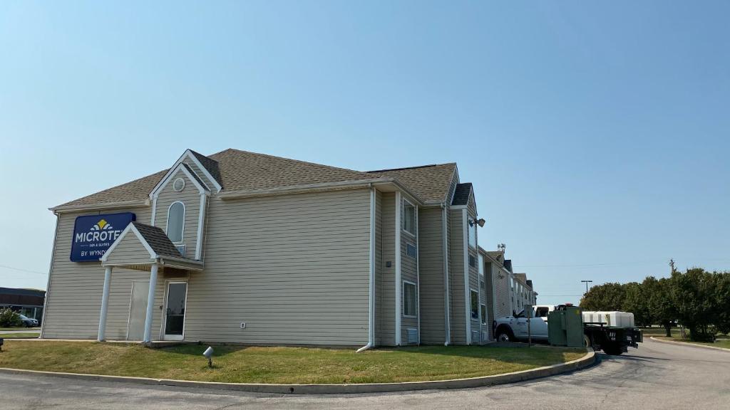 a house with a truck parked in front of it at Microtel Inn & Suites by Wyndham Ardmore in Ardmore