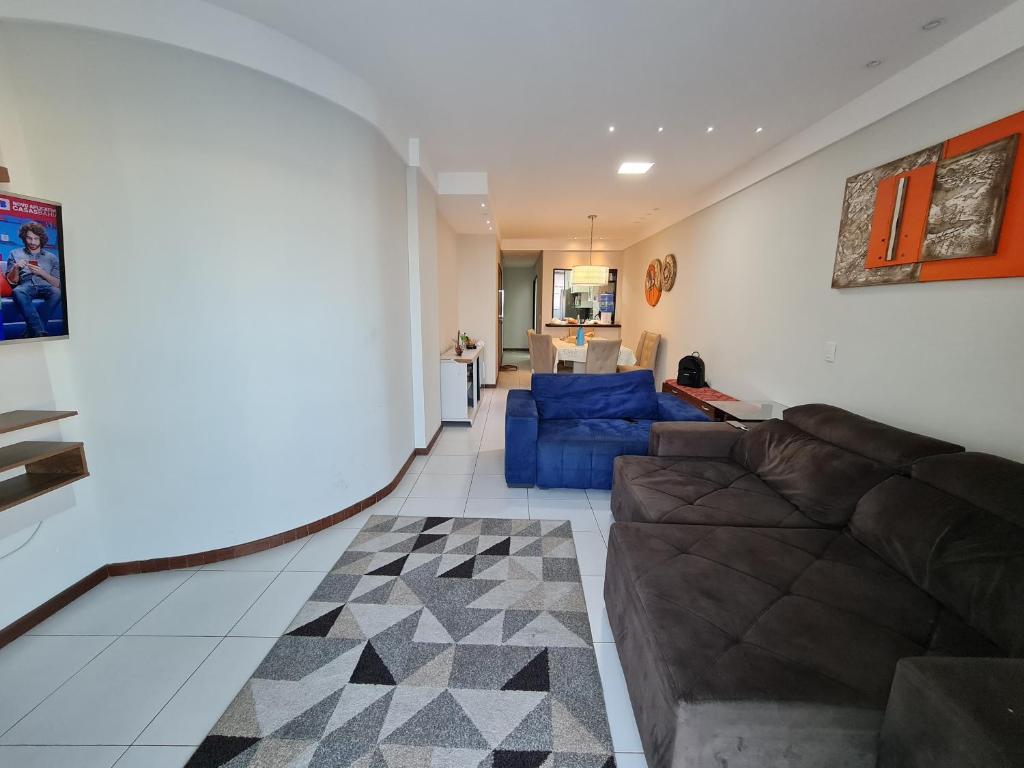 a living room with a couch and a blue sofa at Apto 3 quartos na Praia do Morro wifi 300Mb vista para o mar 2vagas garagem 1 rua da da praia in Guarapari