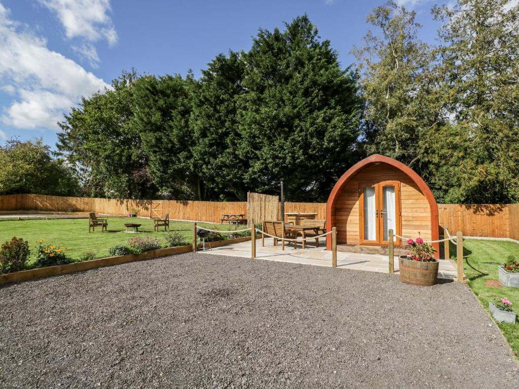 a garden with a small wooden pavilion with a patio at Halmore Pod in Berkeley