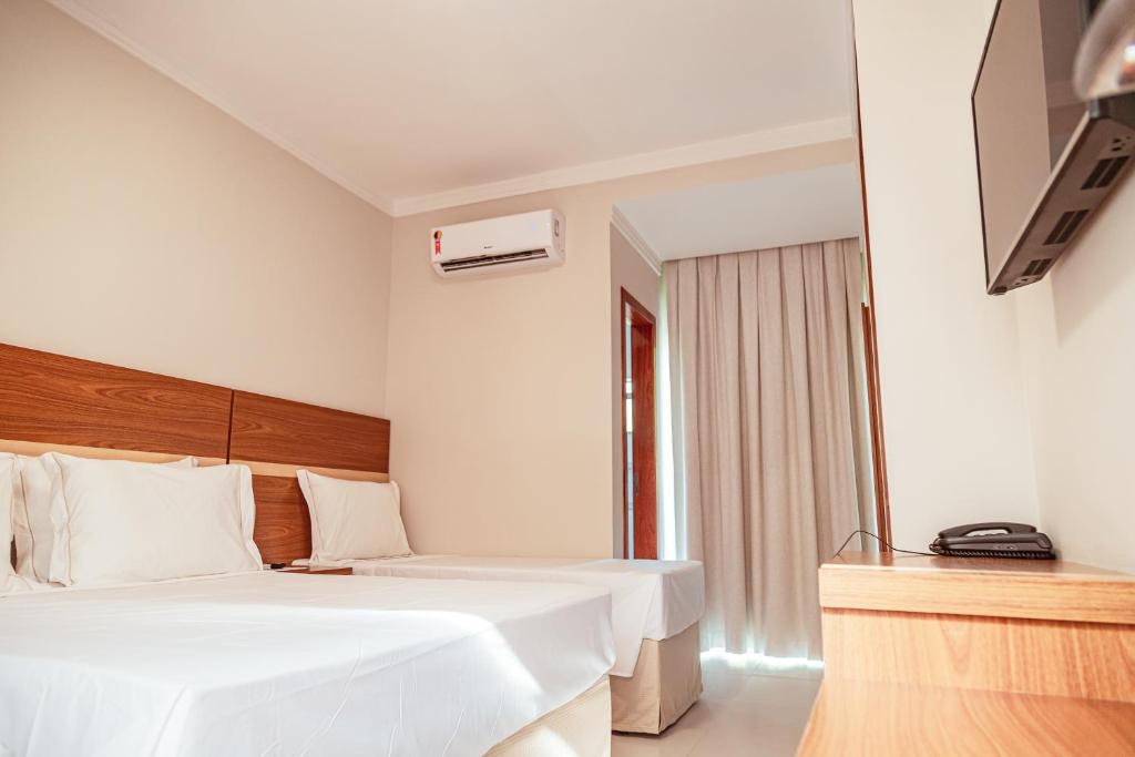 Postel nebo postele na pokoji v ubytování Orquídeas Praia Hotel