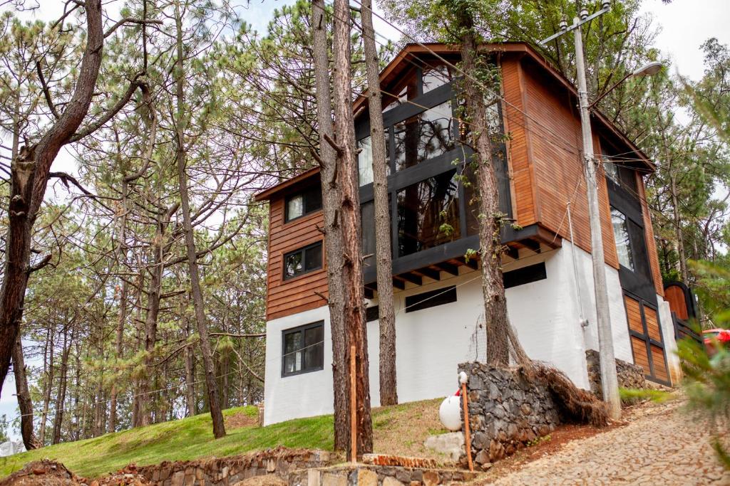 Ein Haus auf einem Hügel im Wald in der Unterkunft Hermosa Cabaña en Mazamitla a 1km del centro - Hermosa vista - Cómodas habitaciones - Todo cerca in Mazamitla