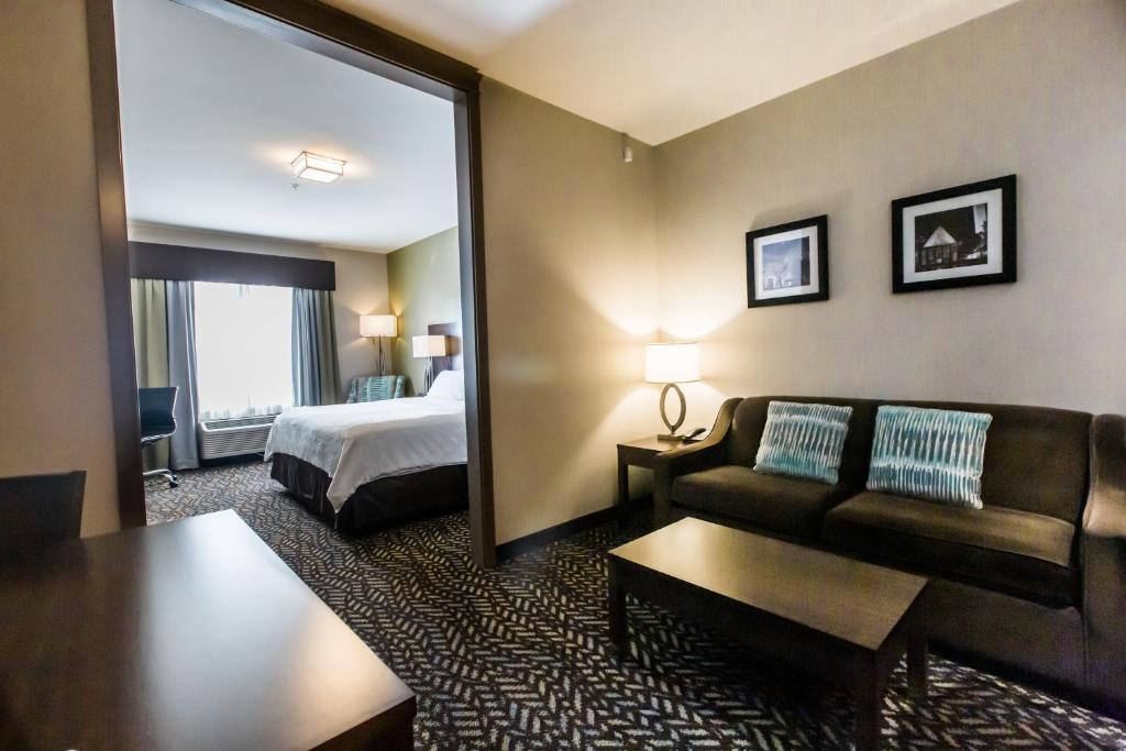 a hotel room with a bed and a couch at Holiday Inn Express & Suites Spruce Grove - Stony Plain by IHG in Spruce Grove