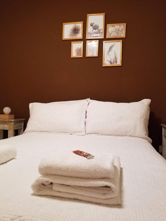 Un dormitorio con una cama blanca con toallas. en Boedo Tango Apartment en Buenos Aires