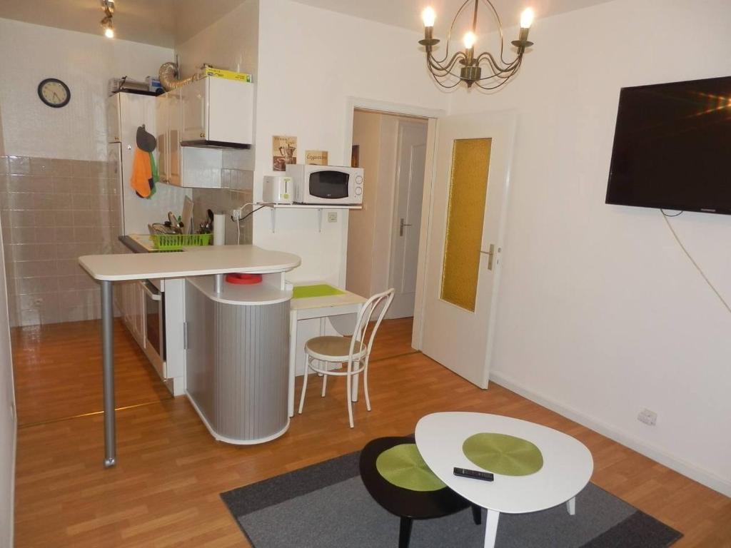 eine kleine Küche mit einem Tisch und Stühlen in einem Zimmer in der Unterkunft Agréable appartement 2 pieces a forbach avec Garage fermé - check in autonome in Forbach