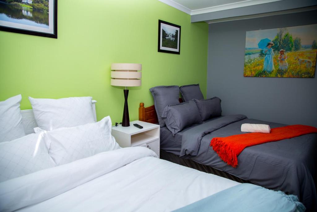 a bedroom with two beds and a couch in it at Relaxing Guest House in th Heart of Ndabeni in Cape Town