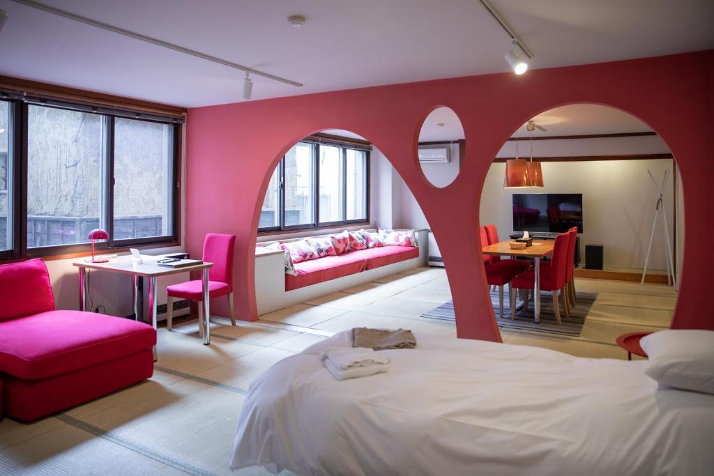 a bedroom with a bed and a red wall at Address Nozawa in Nozawa Onsen