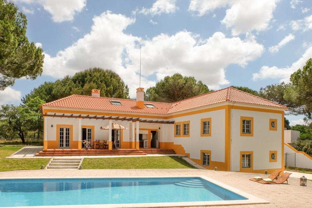 une maison avec une piscine en face de celle-ci dans l'établissement 4 bedrooms villa with private pool enclosed garden and wifi at Comporta, à Montalvo