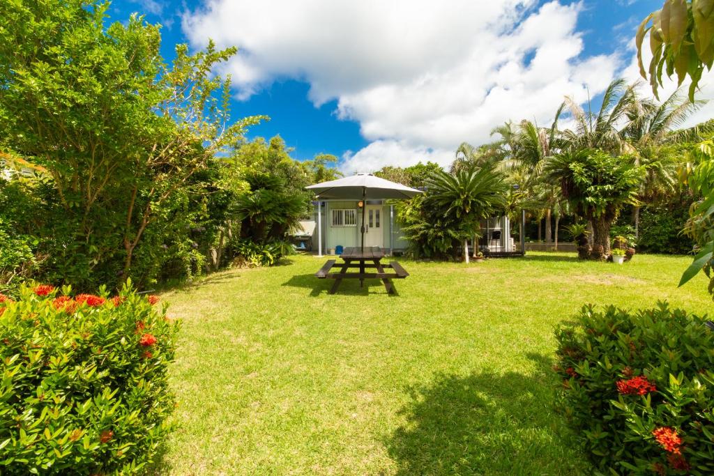 um jardim com uma mesa de piquenique e uma casa em Villa Itona em Ishigaki Island