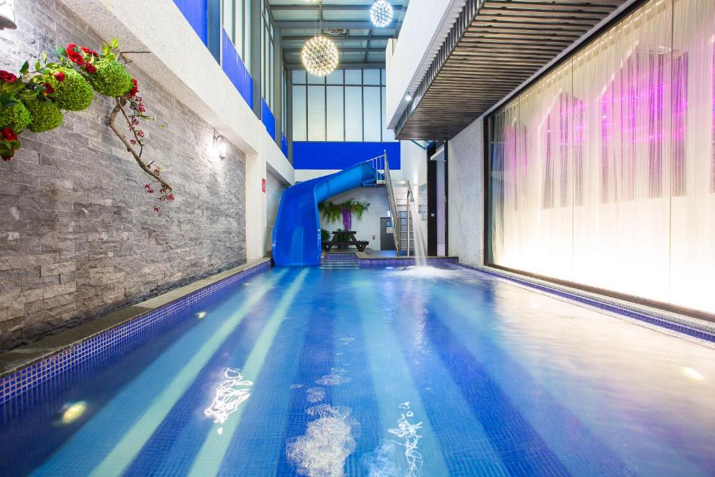 a large swimming pool with a slide in a building at Icloud Luxury Resort &amp; Hotel in Taichung