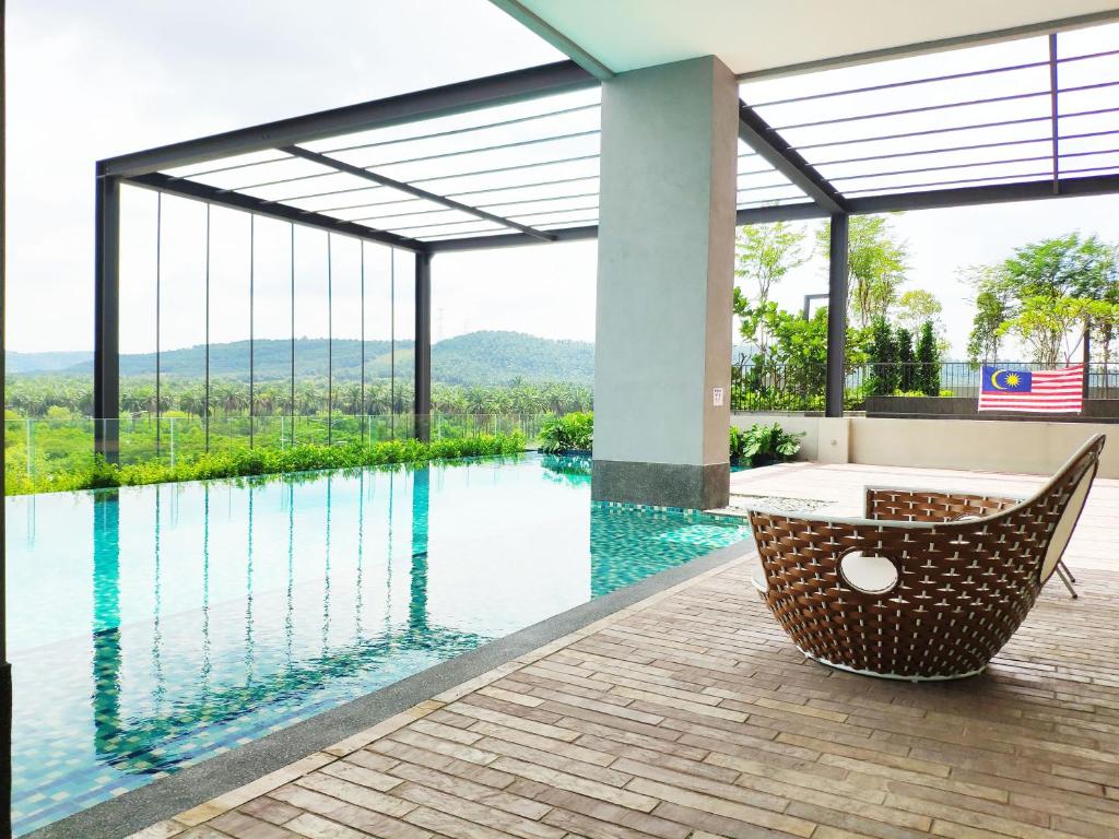 a room with a view of a pool and a chair at Bell Suites by Salaam Suites, Sepang in Sepang