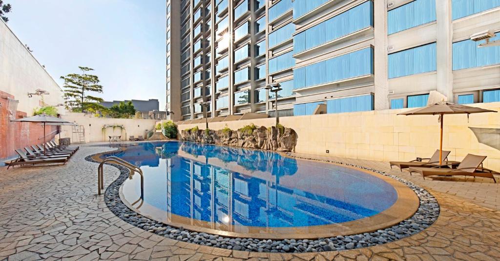 una grande piscina di fronte a un edificio di Harbour Plaza 8 Degrees a Hong Kong