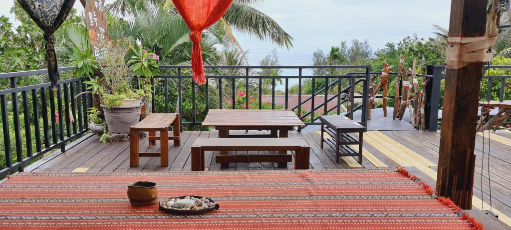 eine Terrasse mit einem Tisch und Bänken auf einem Balkon in der Unterkunft Auntie's Flowers Homestay in Changbin